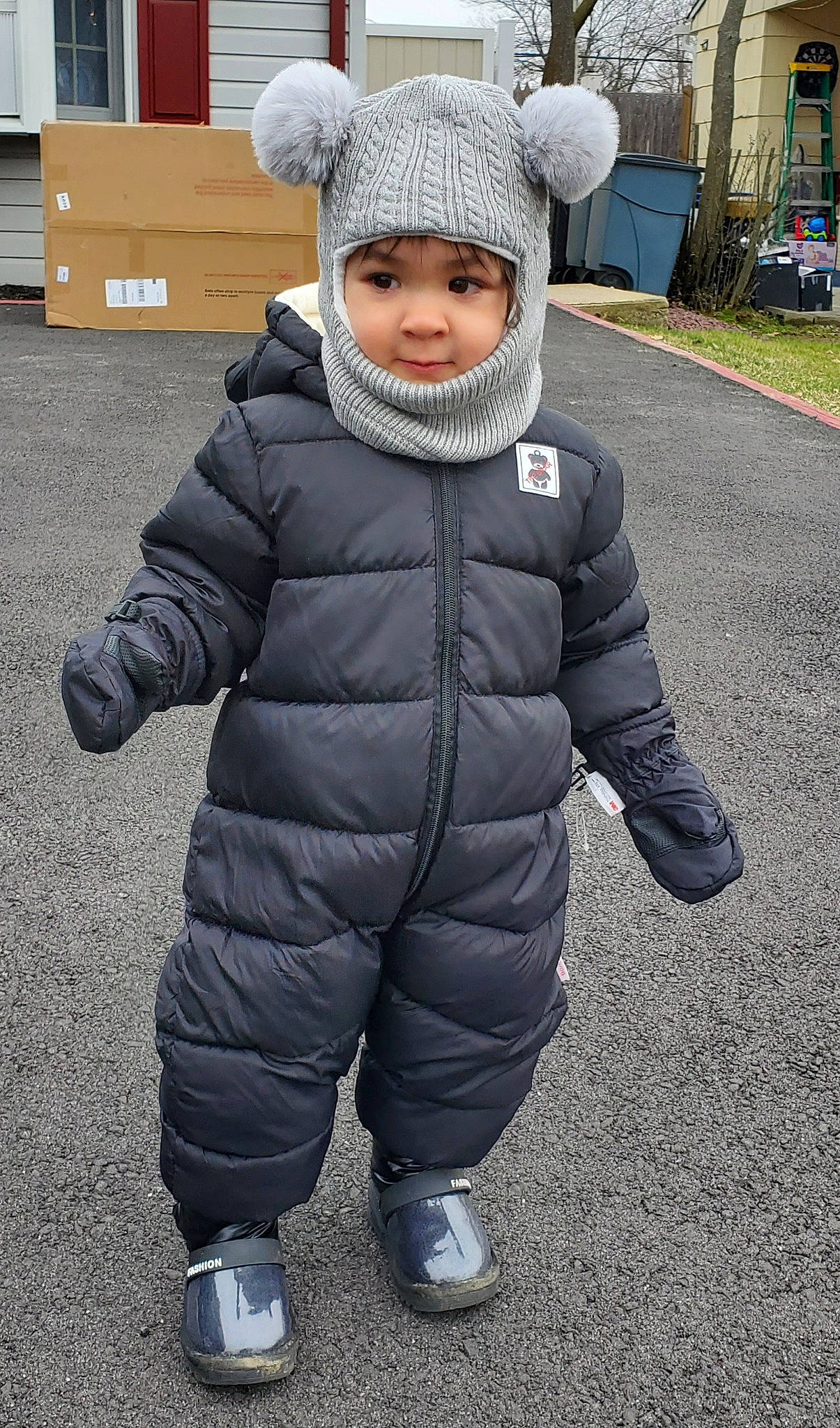 Ariana is registered to the contest to win money with this photo: asphalt, baby, cap, face, freezing, fun, fur, grass, head, headgear, headwear, jacket, knit_cap, person, plant, recreation, road_surface, sleeve, smile, toddler