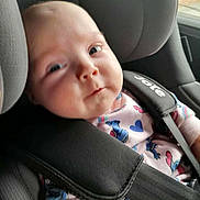 Isabella-Grace is registered to the contest to win money with this photo: baby, car_seat, child, infant, seatbelt, clothing, onesie, heart_pattern, blue, pink, straps, face, person, car_interior, window, safety, cute, young_child, portrait, closeup
