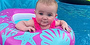 Lexley joined the competition — help win amazing prizes! baby, child, pool, water, inflatable, float, pink, blue, green, swimming, summer, outdoor, backyard, person, relaxing, fun, cute, face, expression, vacation