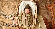 Jaxon is registered to the contest to win money with this photo: newborn, baby, basket, knitted_wrap, hat, sleeping, woven_basket, rug, wooden_floor, texture, cozy, swaddled, peaceful, infant, soft_lighting, natural_colors, indoor, portrait, resting, cute
