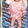 baby, infant, blanket, patterned, pink_bib, floral_outfit, booties, pillow, lying_down, indoors, cute, child, face, head, legs, feet, clothing, baby_girl, portrait, soft_lighting