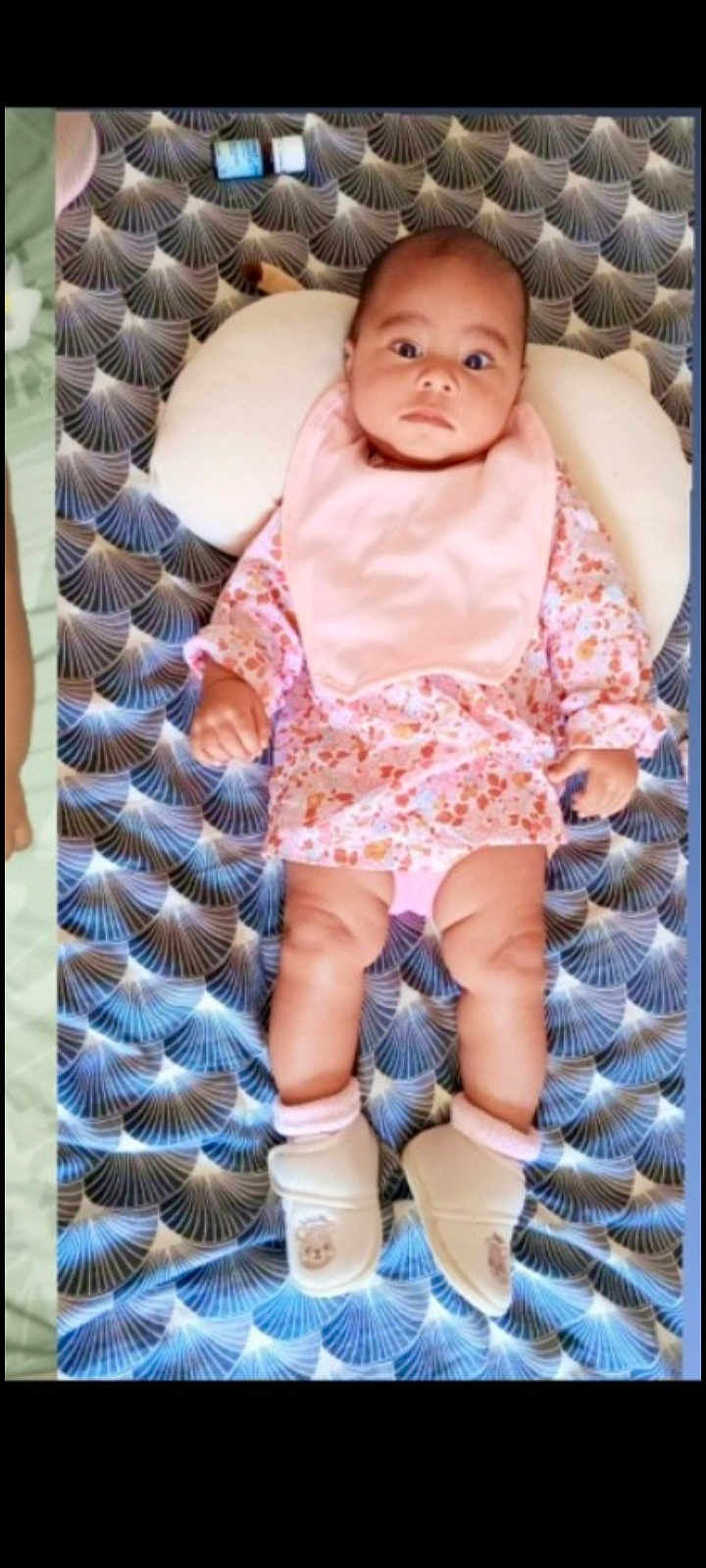 Farah participe au concours pour gagner de l'argent avec cette photo : baby, infant, blanket, patterned, pink_bib, floral_outfit, booties, pillow, lying_down, indoors, cute, child, face, head, legs, feet, clothing, baby_girl, portrait, soft_lighting