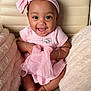 Leora is registered to the contest to win money with this photo: baby, child, pink_clothing, headband, smiling, happy, cushion, fabric, sitting, cute, indoor, infant, skin, face, hands, feet, soft_texture, comfort, portrait, closeup