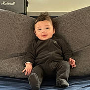 Lucas participe au concours pour gagner de l'argent avec cette photo : baby, child, infant, smiling, face, cushion, gray, clothing, sitting, indoors, marshall_speaker, cozy, happy, young_child, portrait, plush, furniture, relaxed, casual, soft