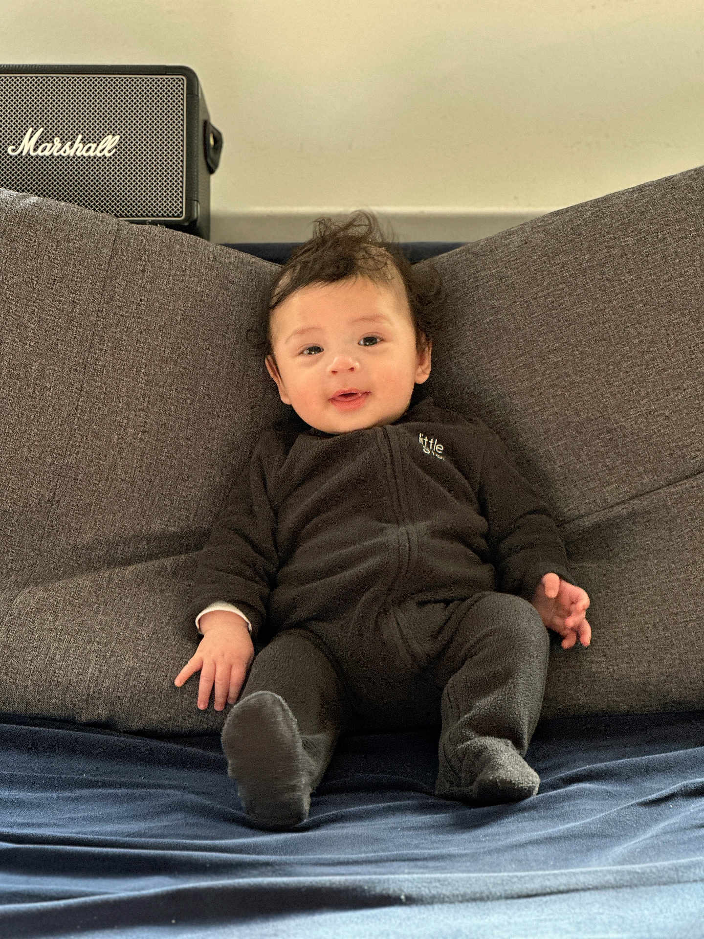 Lucas participe au concours pour gagner de l'argent avec cette photo : baby, child, infant, smiling, face, cushion, gray, clothing, sitting, indoors, marshall_speaker, cozy, happy, young_child, portrait, plush, furniture, relaxed, casual, soft