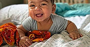 Atharv joined the competition — help win amazing prizes! baby, bed, blanket, child, colorful_cloth, crib, cute, fabric, face, happy, home, indoors, infant, lying_down, onesie, person, portrait, smiling, soft_lighting, young_child