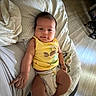 Noah Isaiah Santos is registered to the contest to win money with this photo: baby, infant, child, portrait, lying_down, bed, bedroom, blanket, pillow, yellow_shirt, diaper, face, smiling, indoors, sunlight, home, baby_clothing, rumpled_bedding, photography, cozy