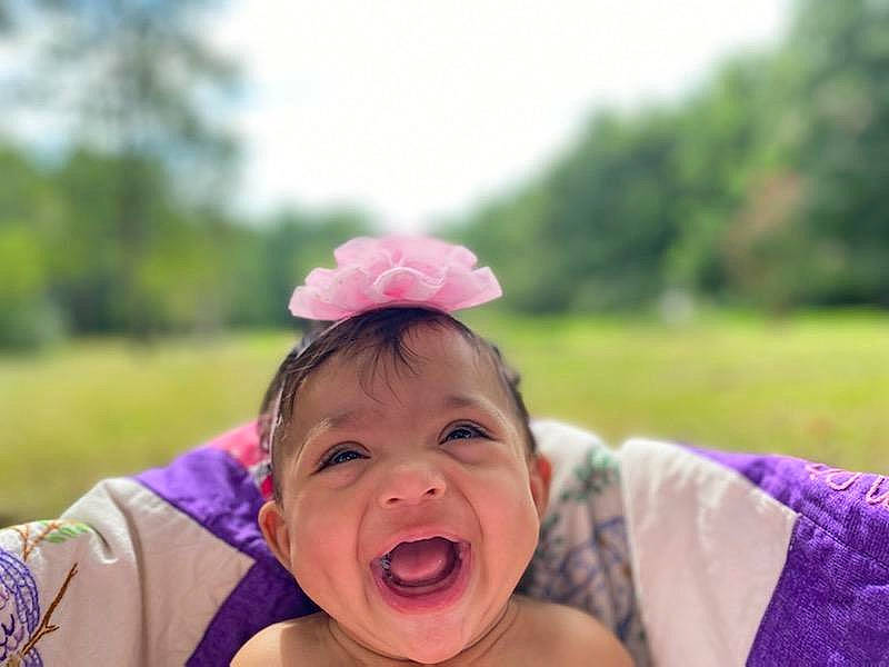 Kensleigh is registered to the contest to win money with this photo: baby, baby_laughing, child, fashion_accessory, fun, grass, grassland, hair_accessory, happy, leisure, magenta, meadow, people_in_nature, person, pink, recreation, skin, sky, smile, toddler
