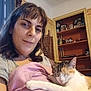 Naia a rejoint le concours — aidez-le/la à gagner de superbes lots ! woman, cat, indoor, blanket, sleeping, calico_cat, person, furniture, shelf, decor, relaxing, cozy, portrait, home, casual_clothing, brown_hair, happy, pet, resting, comfort