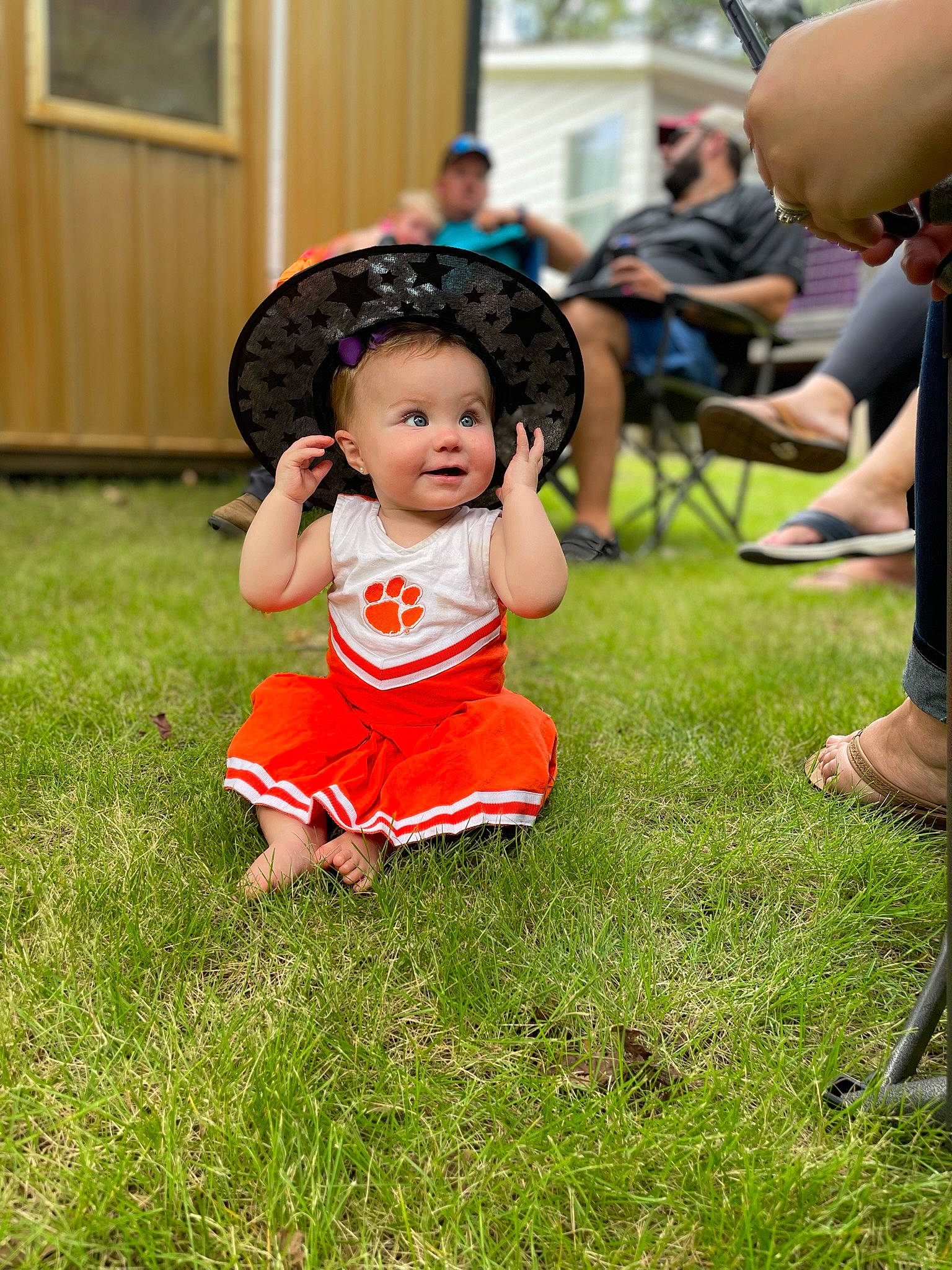 Macie is registered to the contest to win money with this photo: baby, chair, child, door, dress, event, fun, grass, happy, hat, lawn, leisure, person, recreation, shoe, shorts, sitting, smile, sneakers, summer