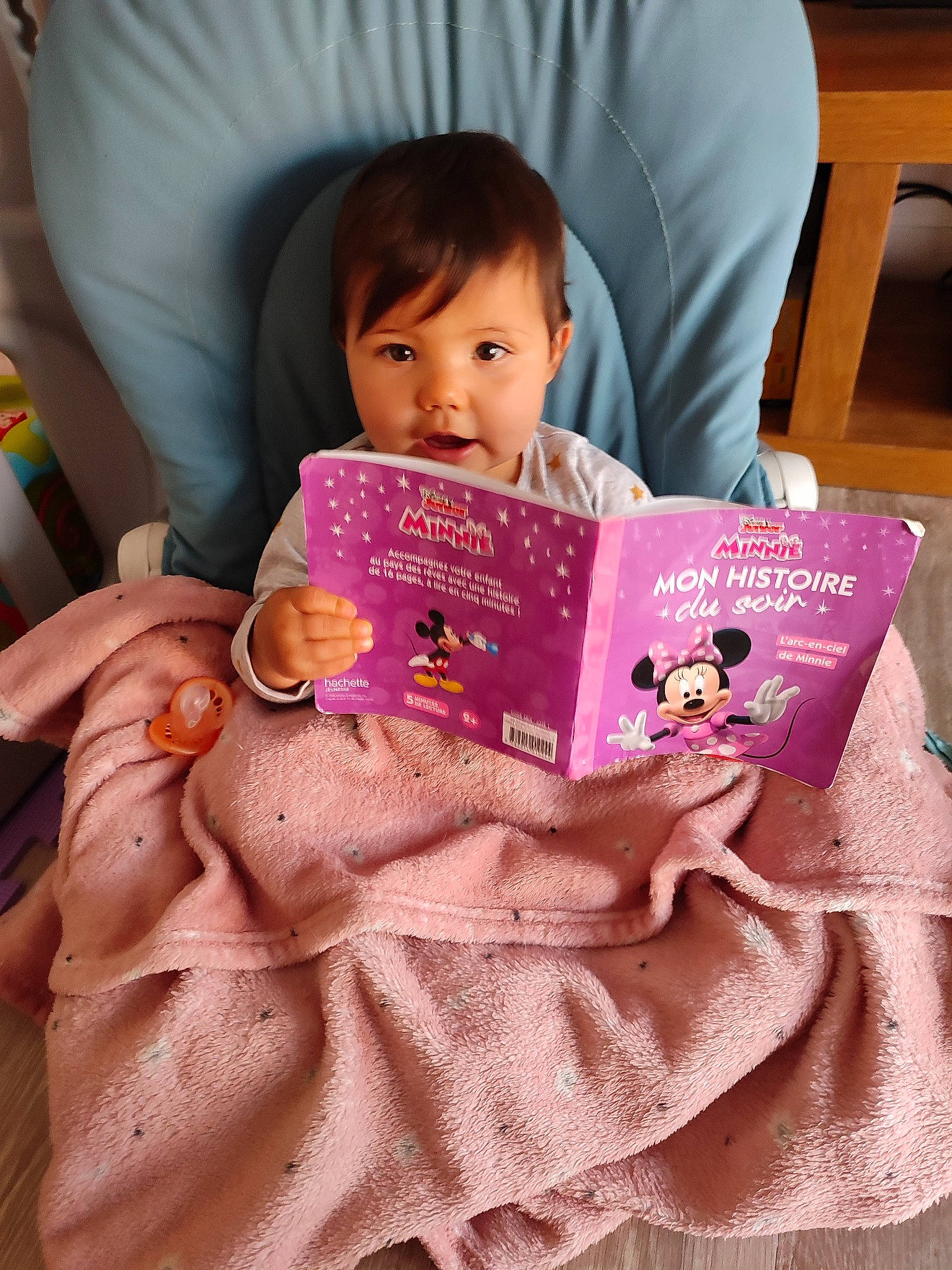 Inès a rejoint le concours — aidez-le/la à gagner de superbes lots ! baby, baby_toddler_clothing, bedtime, book, book_cover, child, comfort, finger, fun, happy, linens, magenta, person, pink, publication, reading, room, sitting, skin, textile