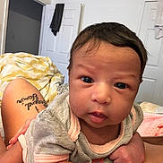 Azariyah is registered to the contest to win money with this photo: baby, infant, person, face, eyes, hair, skin, clothing, bedroom, blanket, tattoo, legs, door, towel, indoor, curious, portrait, human, expression, closeup
