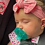 baby, pacifier, car_seat, headband, pink_bow, child, sleepy, infant, cute, straps, clothing, face, closeup, seatbelt, adorable, young_child, heart_pattern, skin, hair, comfort