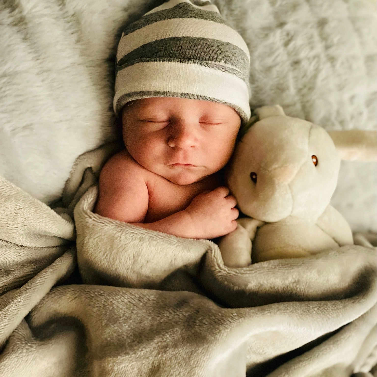 Baylor is registered to the contest to win money with this photo: baby, baby_sleeping, bedding, bedtime, cap, cheek, child, comfort, finger, fur, gesture, hand, happy, interaction, linens, skin, textile, toddler, white, wool