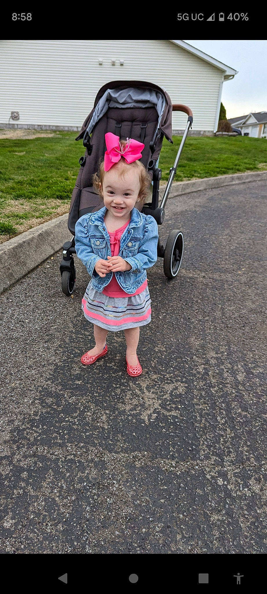 Blythe is registered to the contest to win money with this photo: asphalt, baby, baby_carriage, child, dress, eye, fun, grass, hand, joy, leisure, person, pink, plant, recreation, road_surface, smile, tire, toddler, travel
