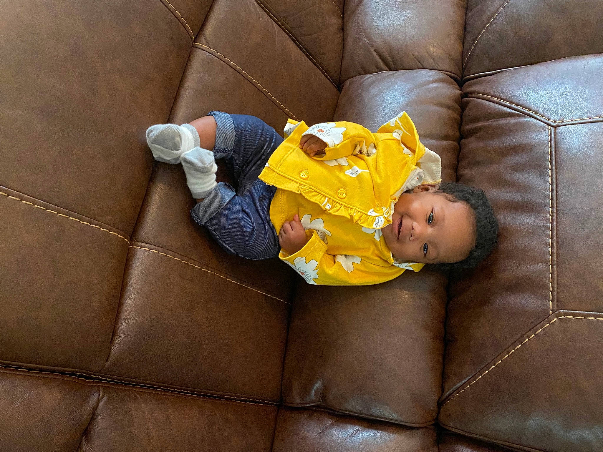 Kamiyah joined the competition — help win amazing prizes! baby, baby_toddler_clothing, child, comfort, couch, floor, flooring, furniture, hardwood, linens, living_room, orange, person, room, sitting, sofa_bed, studio_couch, textile, toddler, wood