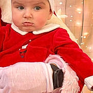 Eden participe au concours pour gagner de l'argent avec cette photo : toddler, child, santa_hat, red_clothing, holiday, christmas, festive, glove, wrapped_presents, warm_lighting, indoor, portrait, cute, face, expression, seasonal, celebration, person, sitting, background