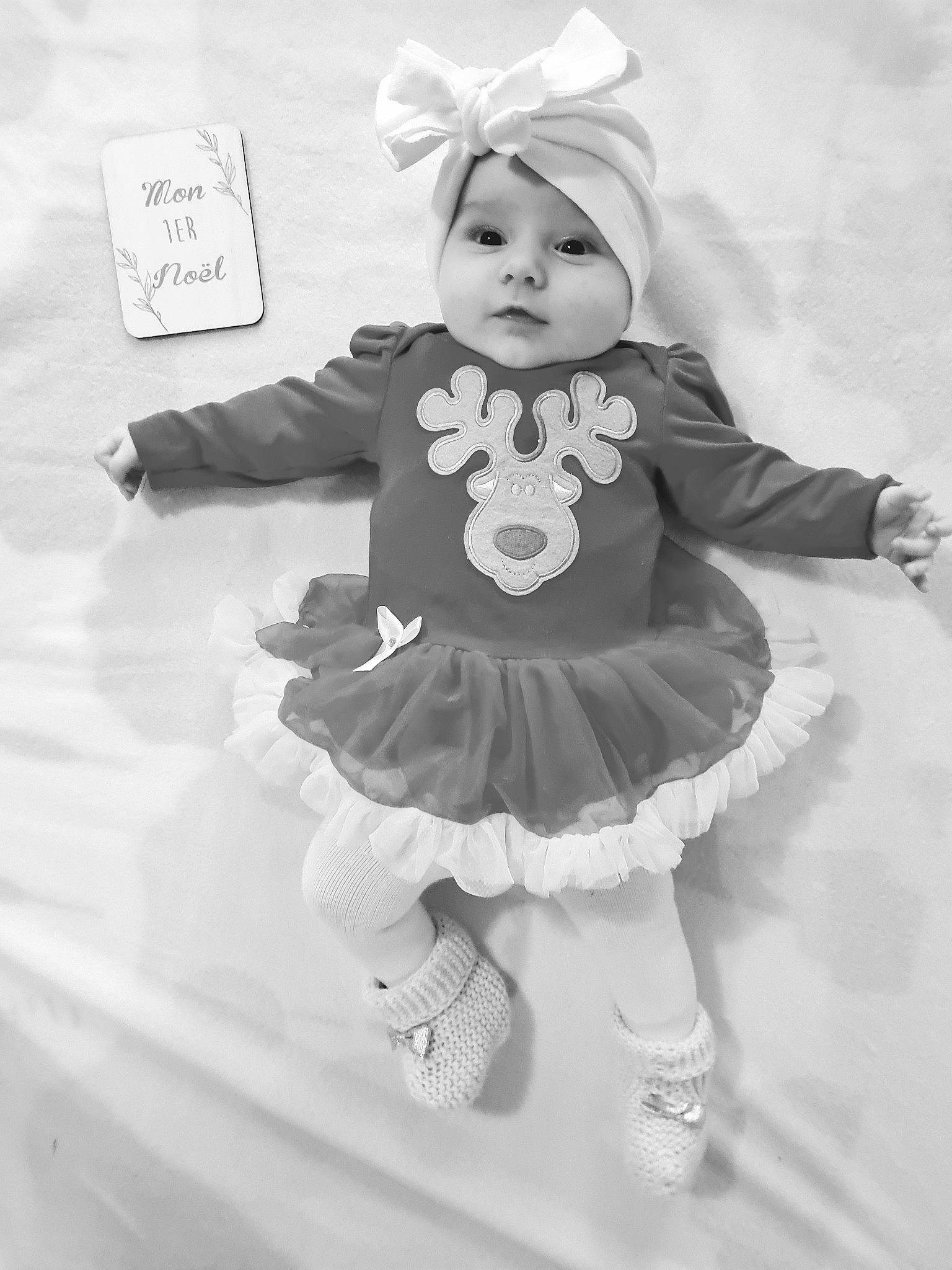 Lana participe au concours pour gagner de l'argent avec cette photo : baby, baby_toddler_clothing, black, black_and_white, costume_hat, day_dress, dress, face, happy, headgear, headpiece, headwear, monochrome, monochrome_photography, party_supply, person, photograph, pink, standing, style