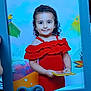 Mila participe au concours pour gagner de l'argent avec cette photo : background, bird, blue_frame, book, child, colorful, curly_hair, cute, frame, girl, happy, holding, indoor, leaf, person, photo_frame, portrait, red_dress, smile, tropical