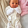baby, infant, onesie, mittens, blanket, pink_blanket, soft_texture, cozy, lying_down, face, head, small_hands, newborn, cute, sleepwear, bed, comfort, portrait, young_child, resting