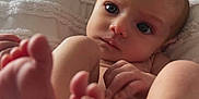 Gracie is registered to the contest to win money with this photo: baby, blanket, close_up, cozy, curious, cute, expression, face, feet, hands, indoors, infant, lying_down, natural_light, newborn, portrait, skin, sleepwear, soft_texture, toddler