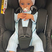Gracie joined the competition — help win amazing prizes! baby, car_seat, pacifier, headband, bow, blue_eyes, knitted_outfit, booties, infant, child, seat_belt, black_seat, cute, portrait, indoors, hands, feet, child_safety, baby_fashion, closeup