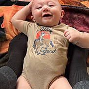 Sutton joined the competition — help win amazing prizes! baby, infant, onesie, clothing, smiling, face, person, legs, blanket, pattern, colorful, socks, hand, cute, happy, lying_down, indoor, child, soft_texture, casual