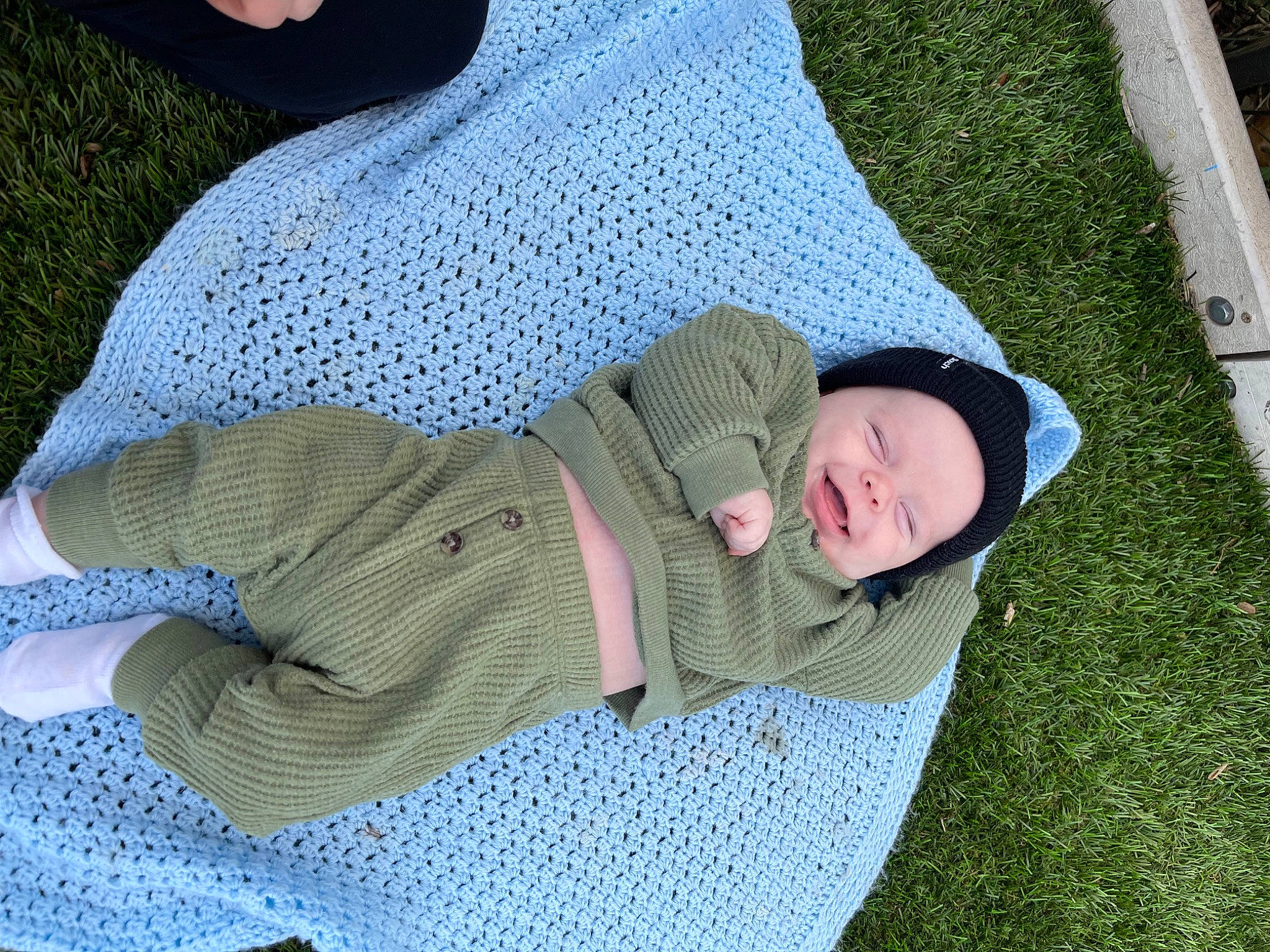 Cade is registered to the contest to win money with this photo: baby, baby_products, baby_toddler_clothing, child, comfort, flooring, grass, grass_family, headwear, lap, lawn, leisure, linens, nap, pattern, person, plant, recreation, sitting, sleep