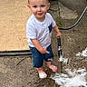 barefoot, blue_eyes, casual_clothing, child, concrete, foam, fun, garden_hose, outdoor, person, playful, shorts, smiling, soap_bubbles, standing, summer, toddler, water, white_shirt, yard