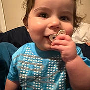 Zamariel is registered to the contest to win money with this photo: baby, blue_shirt, child, closeup, clothing, curly_hair, cute, face, hand, happy, heart_shaped_object, indoor, infant, person, portrait, sitting, skin, smiling, toddler, young_child