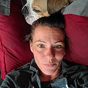 Cheese joined the competition — help win amazing prizes! animal, bond, bulldog, casual, closeup, comfort, dog, face, gray_shirt, head, human, indoor, lying_down, pet, pillow, portrait, red_pillow, relaxed, resting, woman
