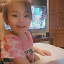 Sasha joined the competition — help win amazing prizes! child, toddler, high_chair, smiling, indoor, hair, face, clothing, pink_shirt, furniture, television, american_flag, room, door, table, happy, person, young_child, cute, casual