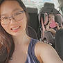 woman, child, car, car_seat, glasses, piercing, toy, heart_shaped, seat_belt, smile, happy, interior, casual, portrait, family, safety, daylight, vehicle, person, road_trip