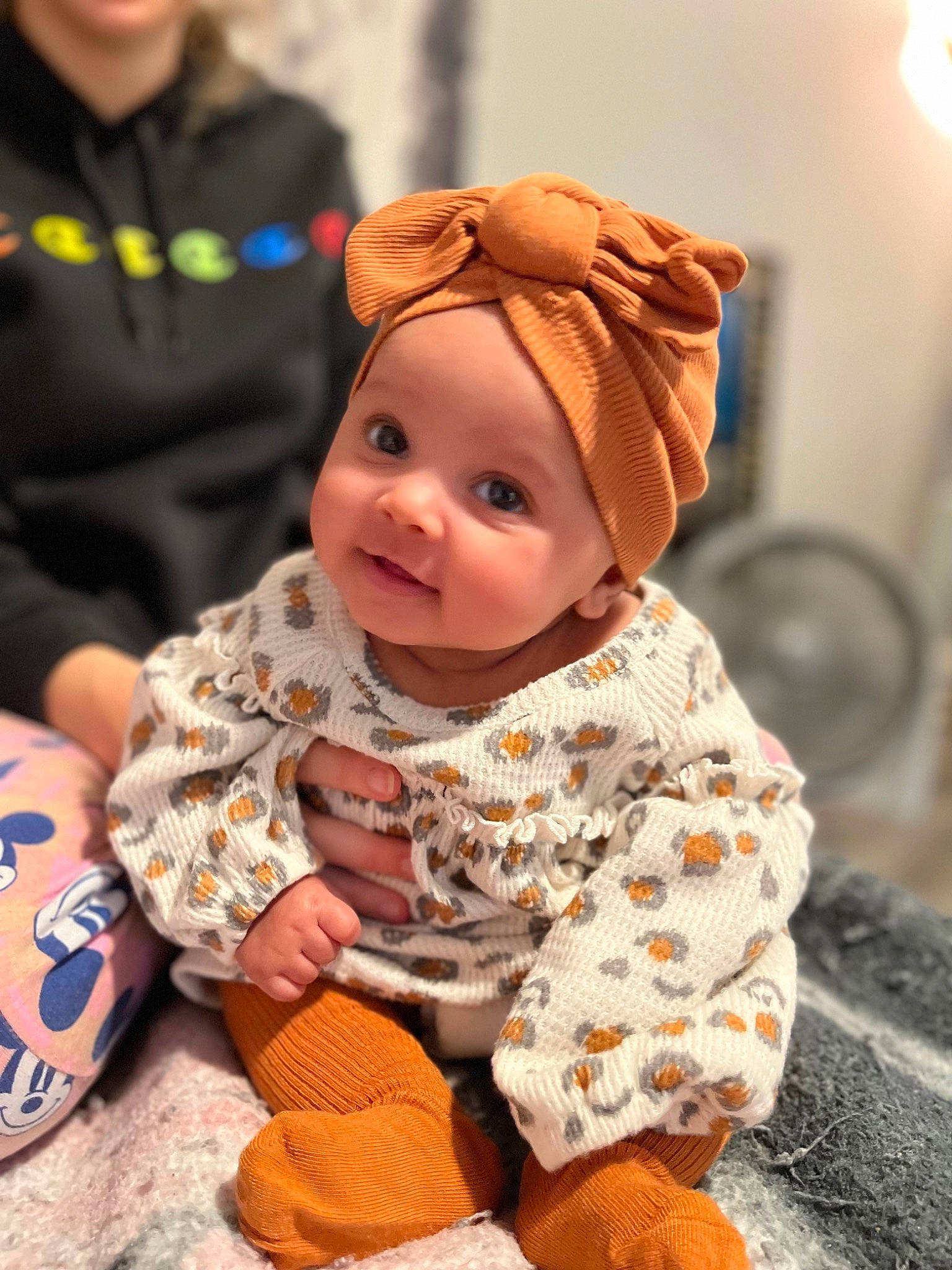 Asia is registered to the contest to win money with this photo: baby, baby_toddler_clothing, bicycle_wheel, cap, cheek, child, comfort, flooring, fun, happy, headgear, headwear, orange, person, room, sitting, skin, smile, tire, toddler