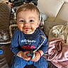 Liam Creciun participe au concours pour gagner de l'argent avec cette photo : toddler, child, face, smile, chocolate, messy, pacifier, clothing, sitting, blanket, couch, indoors, happy, baby, person, toy, blue_clothing, floor, casual, home