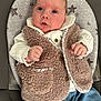 Margot Lynda Stirk is registered to the contest to win money with this photo: baby, infant, vest, white_shirt, blue_jeans, cushion, star_pattern, clothing, face, hand, fist, seated, indoor, cute, young_child, portrait, expression, fabric, comfort, looking_up