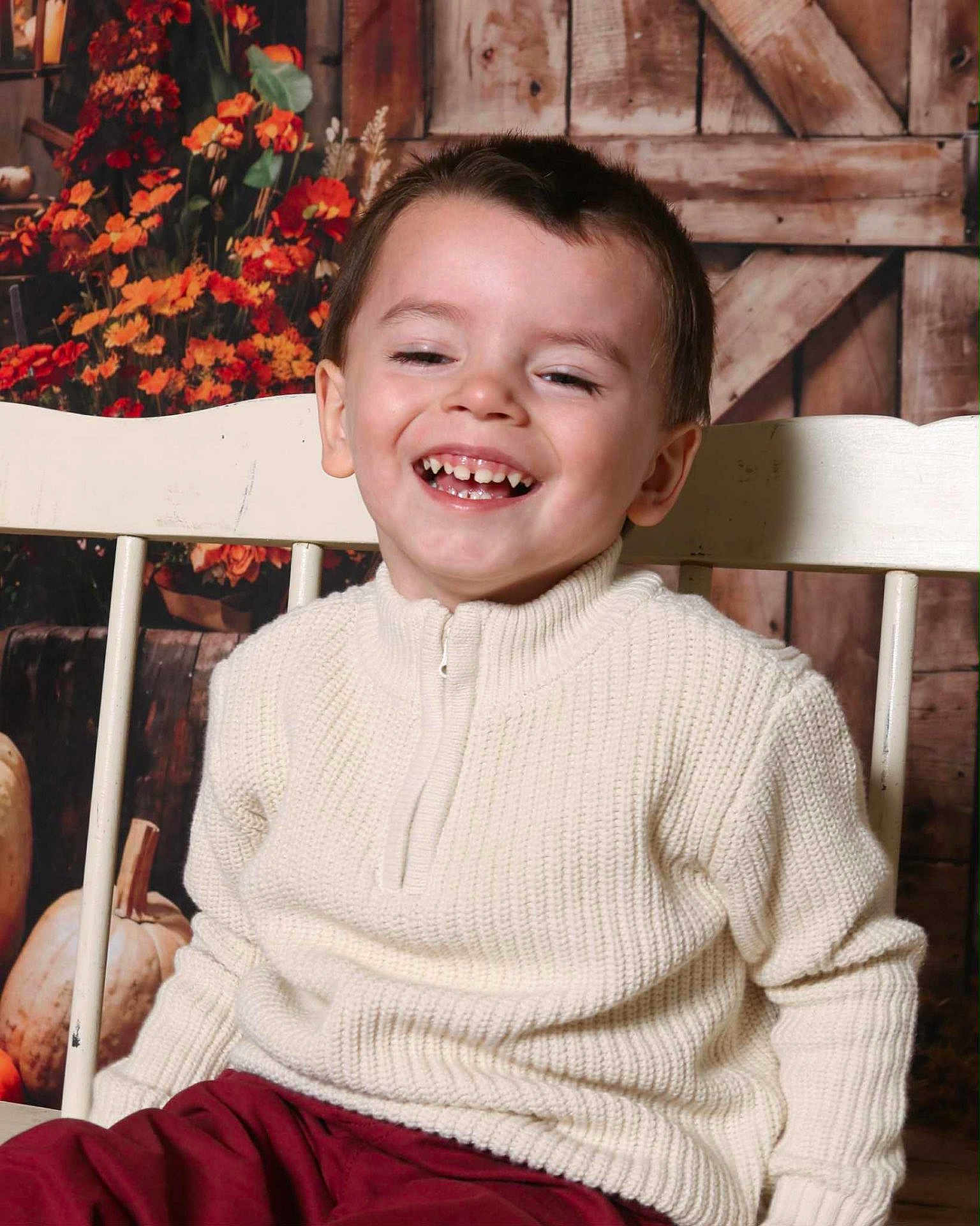 Liam joined the competition — help win amazing prizes! child, boy, smile, sweater, chair, pumpkins, flowers, autumn, portrait, happy, indoor, rustic, cozy, young, casual_clothing, seated, background, wood, warm_colors, cute