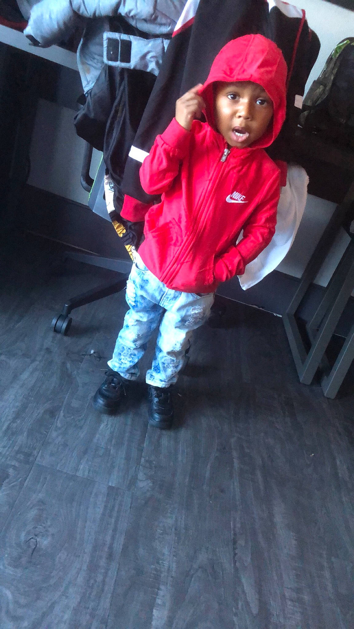 Prince is registered to the contest to win money with this photo: baby, baby_toddler_clothing, bonnet, boot, carmine, child_model, cool, denim, floor, flooring, headwear, hood, hoodie, jacket, jeans, outdoor_shoe, person, surprise, toddler, walking_shoe