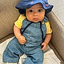 baby, bucket_hat, casual, child, clothing, comfortable, couch, curious, cute, denim_overalls, fabric, footwear, indoor, infant, portrait, seated, sneakers, white, wide_eyes, yellow