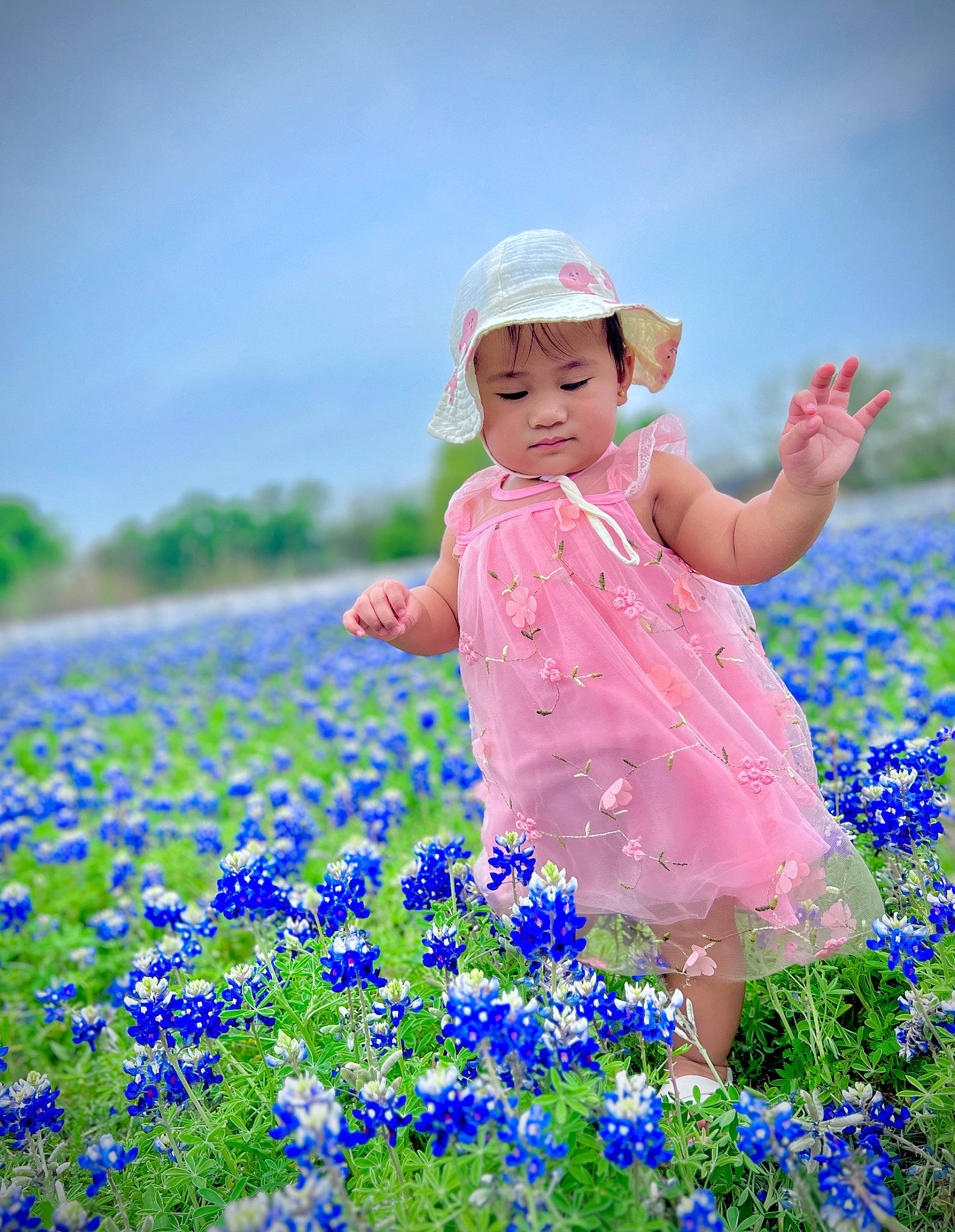 Keisha is registered to the contest to win money with this photo: azure, baby_toddler_clothing, child, electric_blue, field, flower, flowering_plant, grass, grassland, groundcover, happy, hat, headwear, meadow, people_in_nature, person, petal, plant, sky, sun_hat