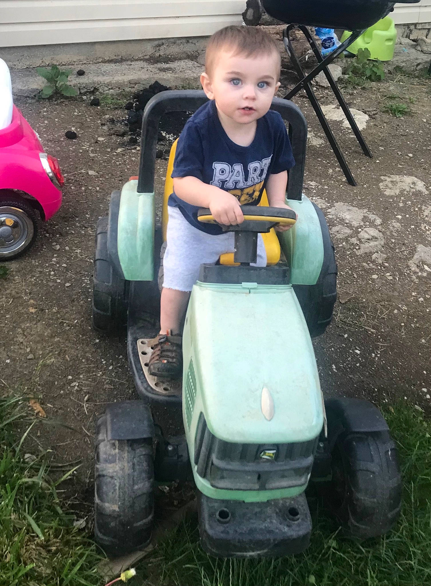 Jay is registered to the contest to win money with this photo: automotive_tire, automotive_wheel_system, bumper, child, fender, fun, grass, green, lawn, lawn_mower, motor_vehicle, person, recreation, riding_toy, shorts, t_shirt, tire, toddler, tread, vehicle