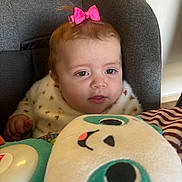 Louna participe au concours pour gagner de l'argent avec cette photo : baby, child, pink_bow, plush_toy, gray_seat, curious, indoor, soft_lighting, cute, infant, face, clothing, toy, comfort, portrait, child_seat, expression, young_child, warm_light, cozy