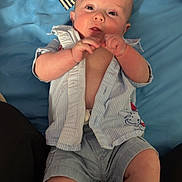 Walker joined the competition — help win amazing prizes! baby, infant, child, portrait, lying_down, blue_bedding, bed, floral_pattern, striped_fabric, clothing, shirt, shorts, barefoot, hands, fists, face, eyes, looking_at_camera, indoors, cozy