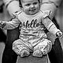 baby, bodypart, clothing, face, finger, footwear, hand, happy, head, longsleeve, pants, person, photography, portrait, shoe, shorts, sitting, sleeve, smile, t_shirt