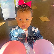 Karter joined the competition — help win amazing prizes! child, toddler, balloons, denim_jacket, pink_bow, hair_braids, indoor, party, celebration, floor_tiles, table, chairs, white_chair_cover, yellow_tablecloth, pink_balloon, purple_balloon, face, person, cute, focused