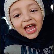 Mateo joined the competition — help win amazing prizes! child, smiling, portrait, close_up, car, indoors, winter_hat, scarf, warm_clothing, black_clothing, toothy_grin, open_mouth, brown_eyes, light_skin, seated, vehicle_interior, selfie, happy, casual, photograph