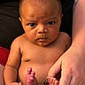 Giuseppe is registered to the contest to win money with this photo: adult_hand, baby, bare_chest, child, closeup, cute, expression, feet, hands, holding, human, indoor, infant, newborn, person, portrait, ring, serious, skin, tattoo