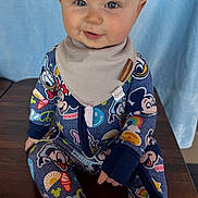 Drew joined the competition — help win amazing prizes! baby, child, smiling, onesie, mickey_mouse, disney, bib, drool, sitting, table, clothing, cute, face, portrait, indoor, infant, happy, person, head, blue_background
