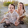 child, children, beach, sand, sunlight, grass, smile, portrait, outdoor, cute, sitting, boy, girl, hair_clip, knitwear, summer, nature, playful, happy, vacation