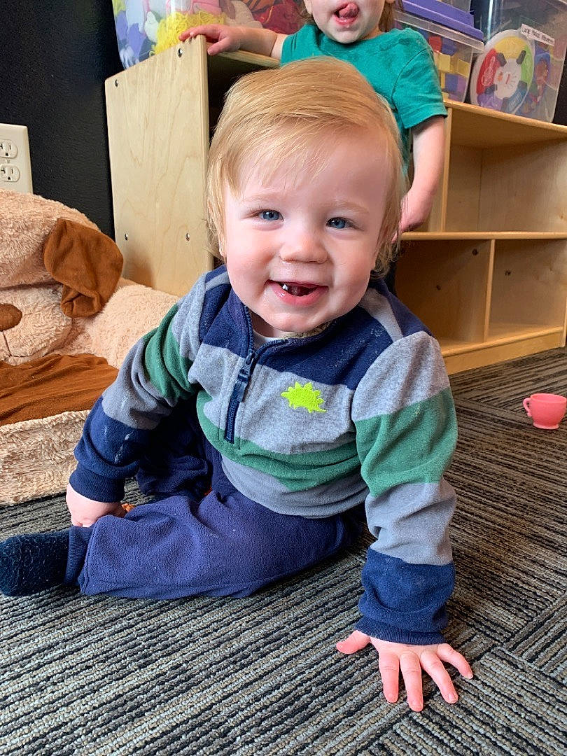 Kaden is registered to the contest to win money with this photo: baby, baby_toddler_clothing, cheek, eye, face, facial_expression, floor, flooring, grass, hair, happy, hardwood, head, iris, person, skin, sleeve, smile, standing, toddler